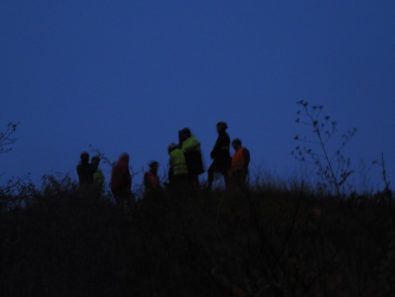 8 cyclistes au sommet vus en contrebas, ciel bleu foncé