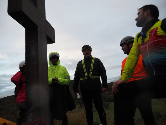 5 cyclistes au sommet, autour d'une croix