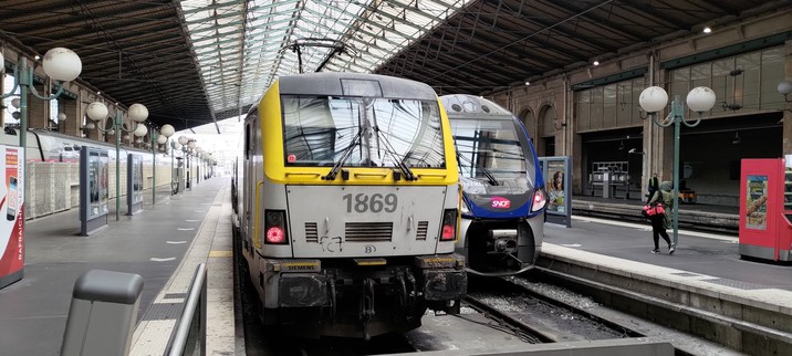 En tête de quai dans une gare une motrice aux couleurs de la sncd et derrière une sncf