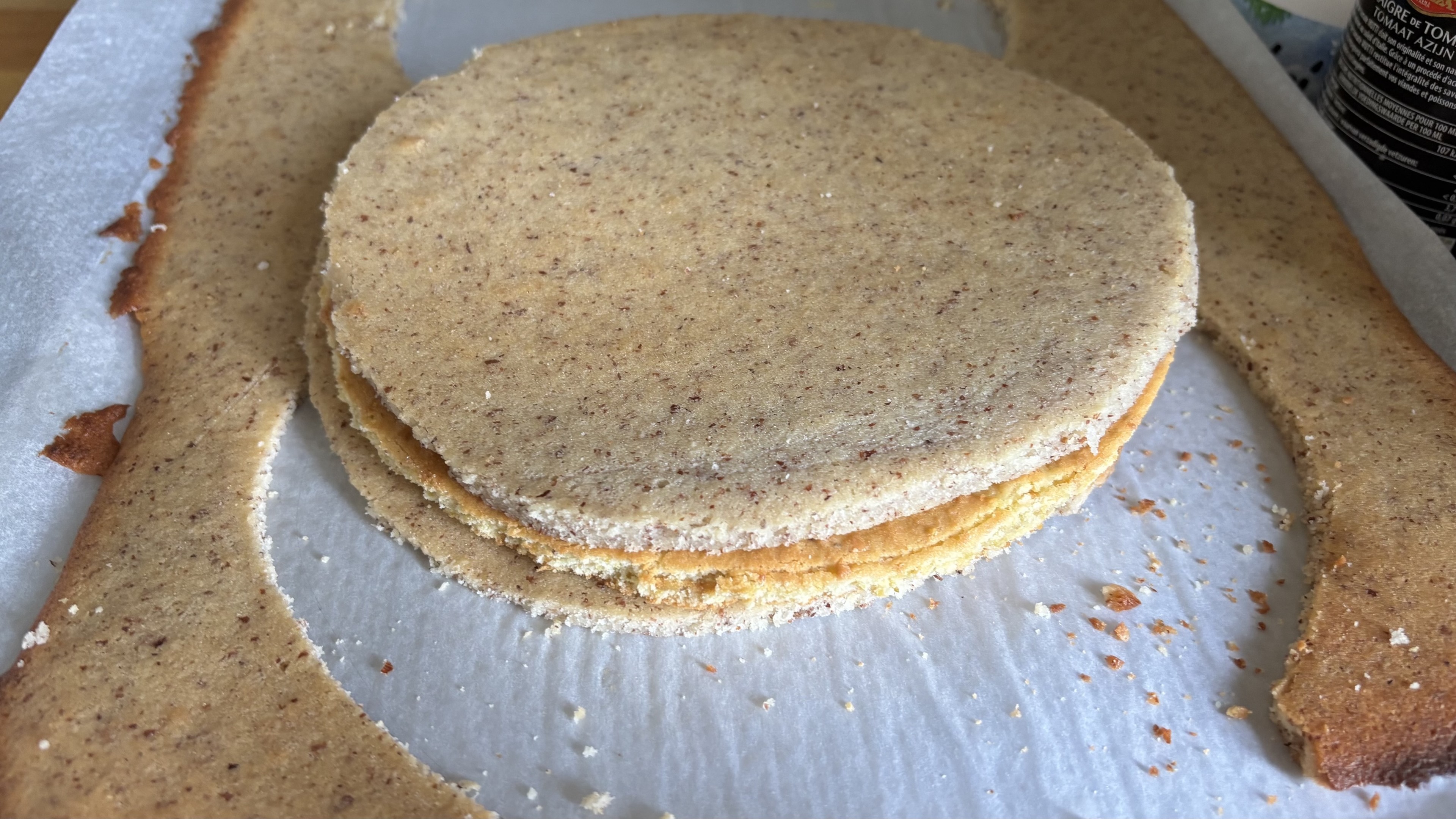 Trois disques de gâteau superposés : deux de financier et un pain de Gène à la pistache au milieu.