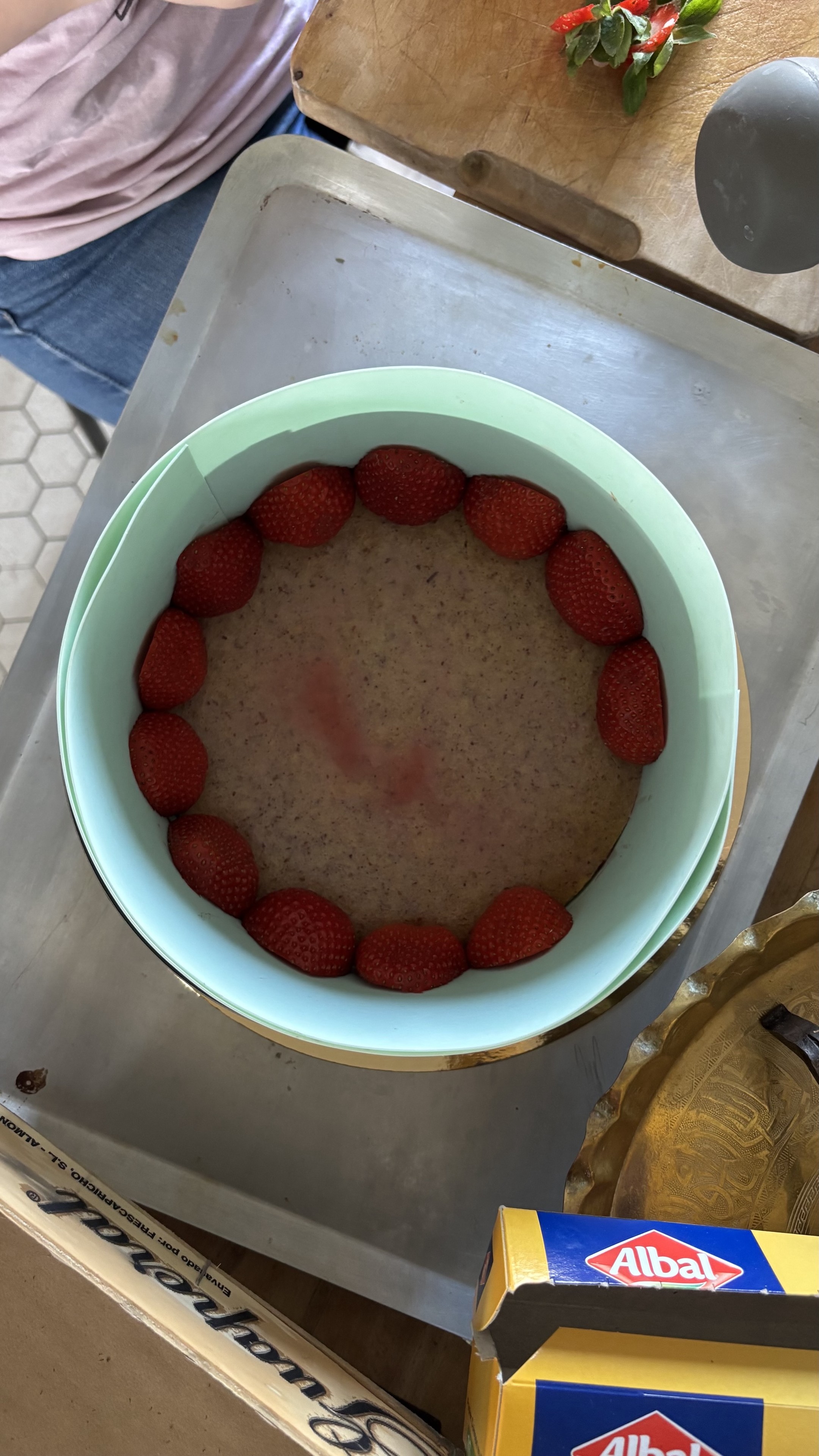 Le cercle est posé sur la plaque et lépremier rang de fraises de décoration est installé.