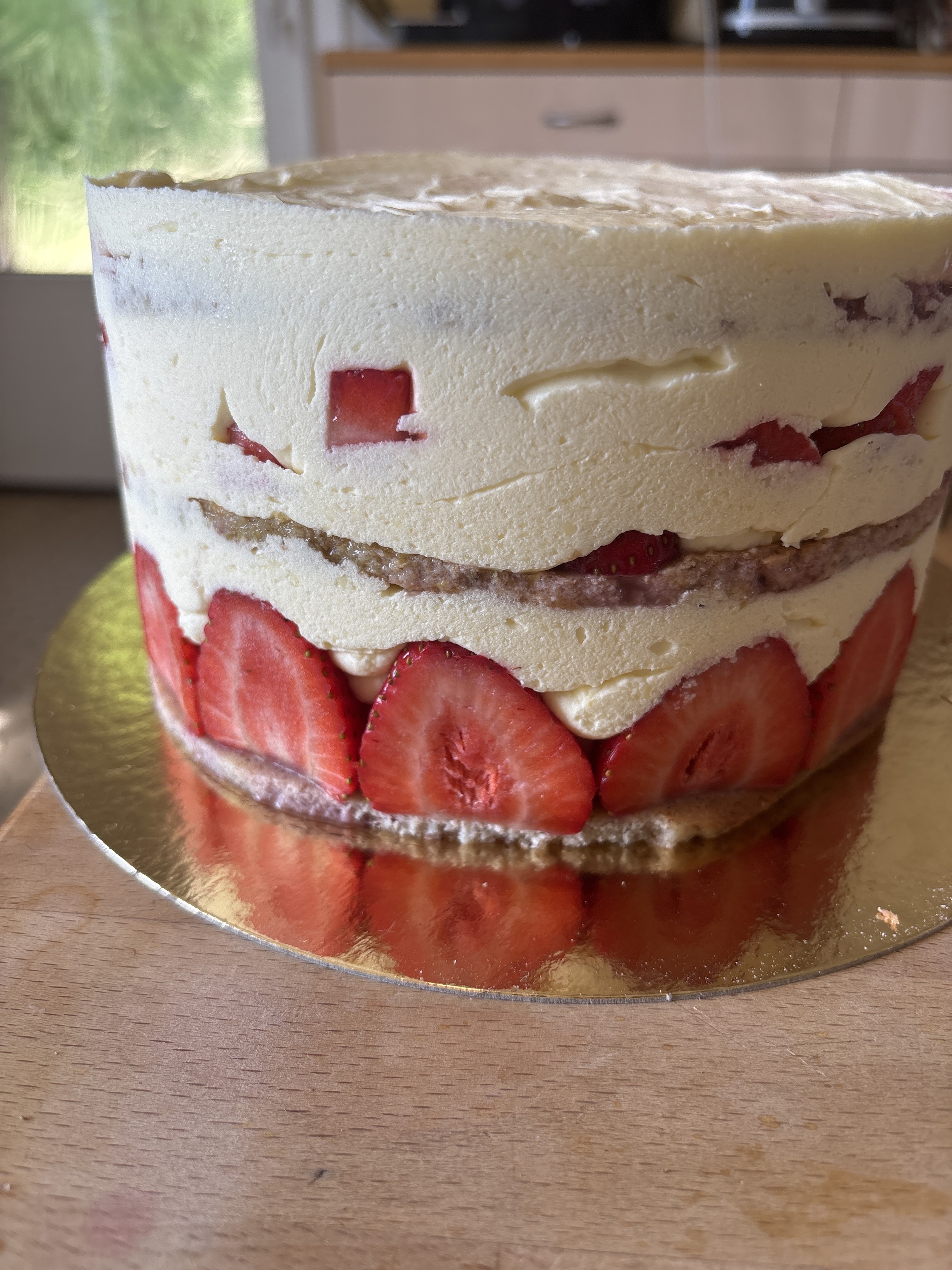 Un énorme fraisier plein de fraises et de crème.